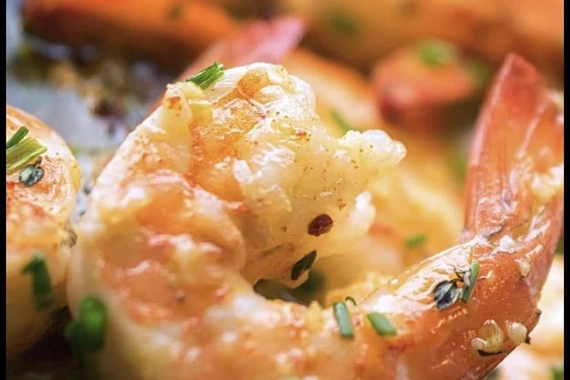 Gambas al pil pil de cerca con cebollino y guindilla en escamas en aceite de oliva, gambas en Marbella